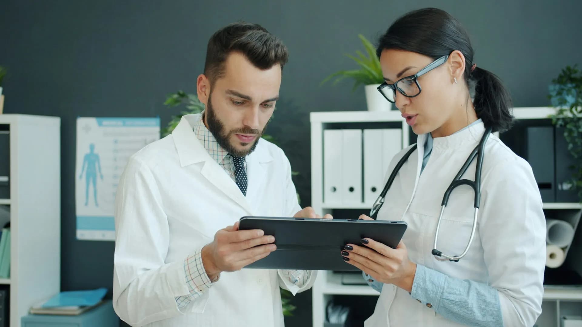 İki hekimin bir tablet üzerindeki görüntüleme sonuçlarını birlikte incelediği klinik ortam